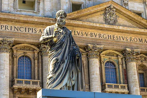 Eine Statue eines Mannes vor einem Gebäude.