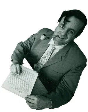 Magen Broshi in a suit holding a sheet of paper.